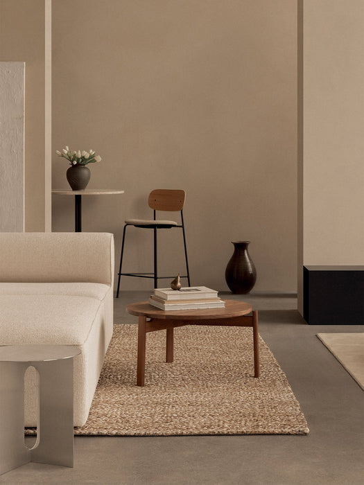 A minimalist living space with a wooden Passage Lounge Table, a cream Eave Modular Sofa, and a Co Counter Chair.