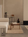 A minimalist living space with a wooden Passage Lounge Table, a cream Eave Modular Sofa, and a Co Counter Chair.