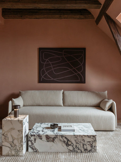 Living room scene featuring a grey Offset Sofa, marble Plinth Low coffee table, and a Plinth side table with a Column Lamp.