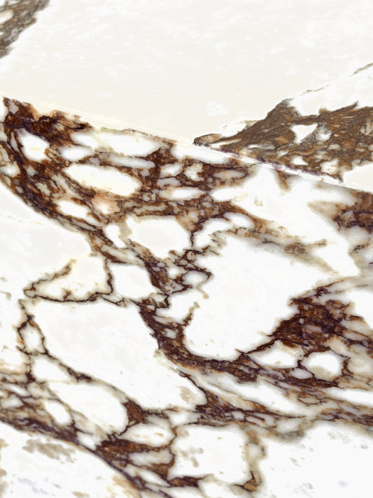A close-up of the corner of the Plinth Low table, showing the detailed purple and brown veining of Calacatta Viola marble.