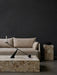 A living room scene with an Offset Sofa, Plinth Grand, Plinth Tall, Interconnect Candle Holder, and Triptych Bowl.