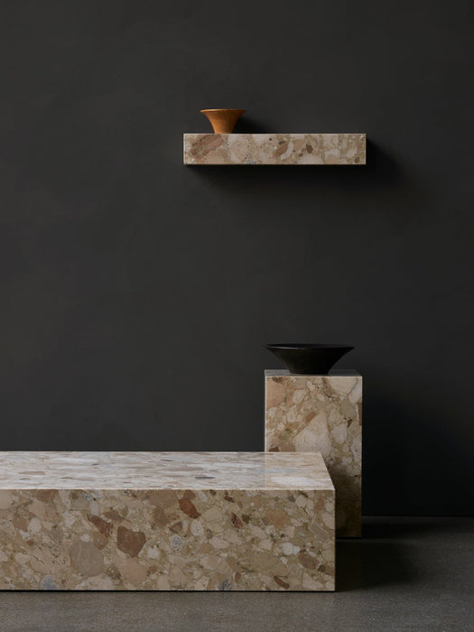 A setting of Plinth Low, Plinth Tall, and Plinth Shelf in patterned marble against a dark wall, styled with a Triptych Bowl.