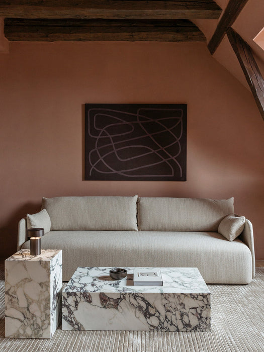 Light-grey Offset Sofa against a terracotta wall with a marble Plinth coffee table, Plinth side table and Column Lamp.