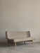 The Radiohus Sofa P2 in light beige upholstery, with a button-tufted backrest and wooden legs, shown in a minimalist room.