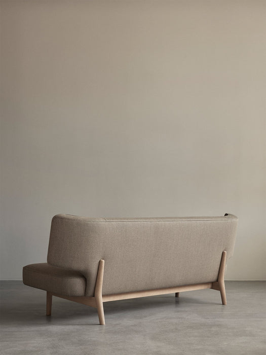 Back view of the Radiohus Sofa P2, showing its curved design with light brown upholstery and natural oak frame.