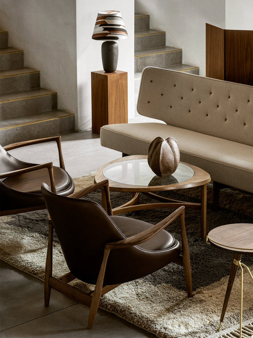 A styled living room featuring the beige tufted Radiohus Sofa P3, two leather armchairs and a glass-topped coffee table.