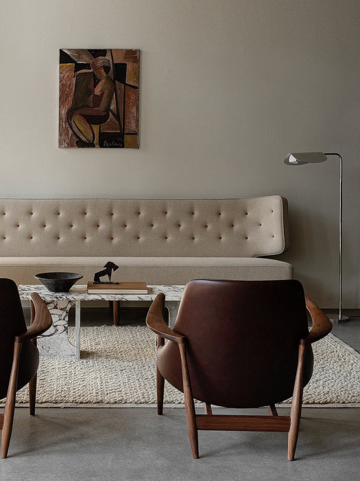 Living room with beige Radiohus Sofa, two Elizabeth Lounge Chairs, marble Androgyne Lounge Table, and Wing Floor Lamp.