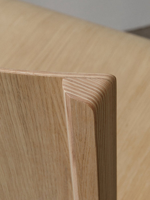 A close-up of the Ready Dining Chair, highlighting natural oak veneer and the layered construction of the backrest corner.