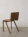 The Ready Dining Chair in red stained oak, seen from a three-quarter back view, highlighting its cantilevered design.