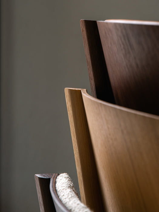 A close-up of the Ready Dining Chair's backrest corner, showing natural oak veneer and layered, form-pressed wood joinery.