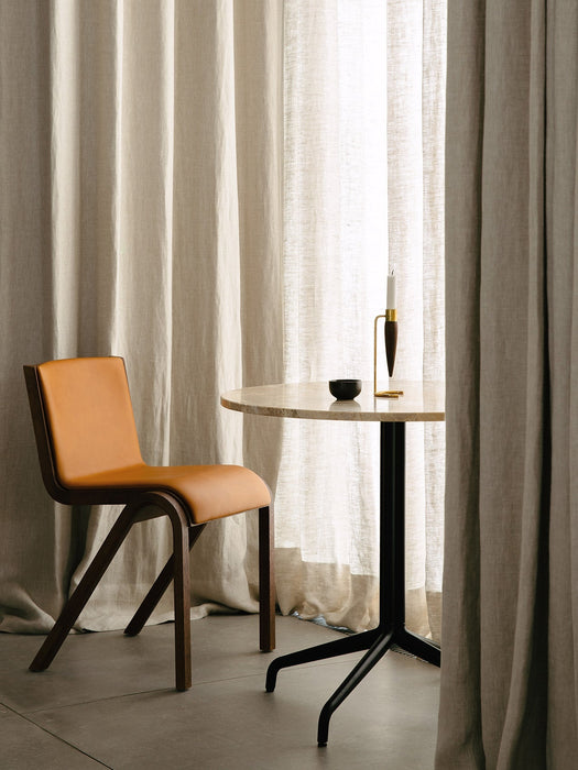 Ready Dining Chair in tan leather next to a Harbour Column Dining Table with a marble top and an Umanoff Candle Holder.