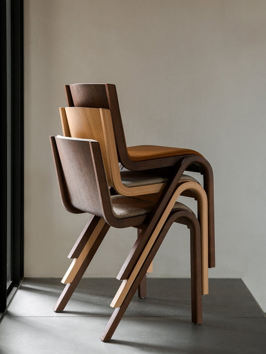 A close-up detail of the Audo Ready Dining Chair in light natural oak, showing the smooth, curved joint of the leg and seat.