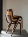 A close-up detail of the Audo Ready Dining Chair in light natural oak, showing the smooth, curved joint of the leg and seat.