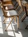 Ready Dining Chairs with upholstered seats in different wood and fabric finishes, arranged in rows on a grey tiled floor.