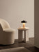The Reverse Table Lamp, Portable on an Androgyne Side Table next to a cream Tearoom Club Chair in a soft-lit room.