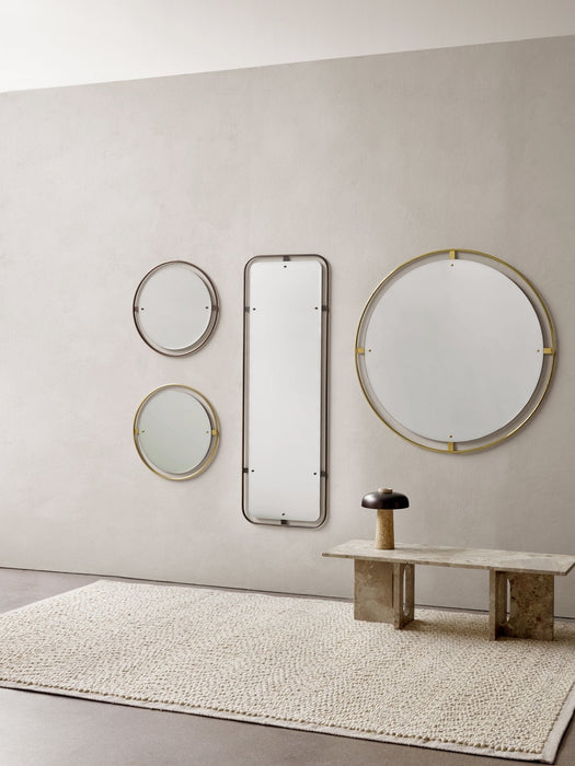 A room setting with Nimbus mirrors on a wall, a Reverse Table Lamp on an Androgyne Lounge Table, and a Gravel Rug.