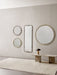 A room setting with Nimbus mirrors on a wall, a Reverse Table Lamp on an Androgyne Lounge Table, and a Gravel Rug.