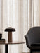 A close-up of the Reverse Table Lamp on a Harbour Column Lounge Table next to the arm of a grey Harbour Lounge Chair.
