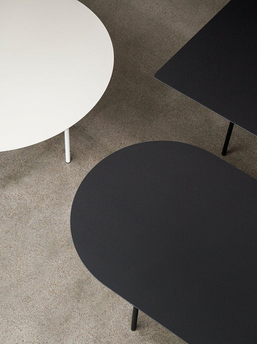 An overhead view of the Snaregade table collection, featuring an oval, a round, and a rectangular table in black and white.