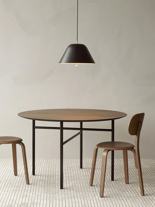 A round Snaregade Dining Table with two Afteroom Plywood Chairs on a Houkime Rug. A black Levitate Pendant hangs overhead.
