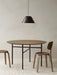 A round Snaregade Dining Table with two Afteroom Plywood Chairs on a Houkime Rug. A black Levitate Pendant hangs overhead.
