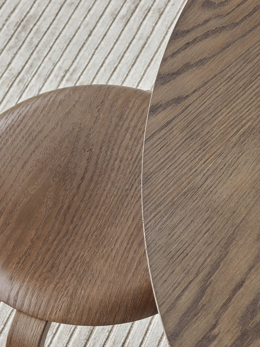 Overhead close-up of the dark oak grain on the Snaregade Dining Table and Afteroom Chair seat, set on a textured Houkime rug.