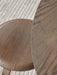 Overhead close-up of the dark oak grain on the Snaregade Dining Table and Afteroom Chair seat, set on a textured Houkime rug.