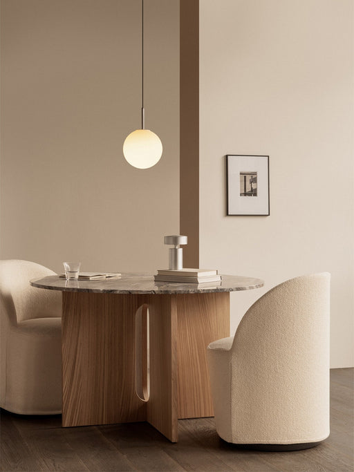 Two cream Tearoom Club Chairs at the Androgyne Dining Table. A TR Bulb Pendant hangs above the grey marble tabletop.