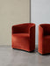 Two Tearoom Club Chairs in burnt-orange velvet fabric, in a minimalist room with a terrazzo floor and a two-toned wall.