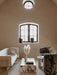 Living room with Tailor Sofa, marble Plinth coffee table, patterned Tearoom Club Chairs, and Gravel Rug under arched windows.