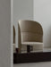 A beige Tearoom Lounge Chair, High Back, sits behind a black marble Plinth table with a Yana Brewing Pot and two cups.