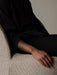 Close-up of the Tearoom Lounge Chair showing the detailed texture of the fabric upholstery with a person's arm resting on it.