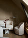 Tearoom Lounge Chair in a dimly lit room with a Tearoom Sofa, Androgyne marble lounge table and a Wing Floor Lamp.