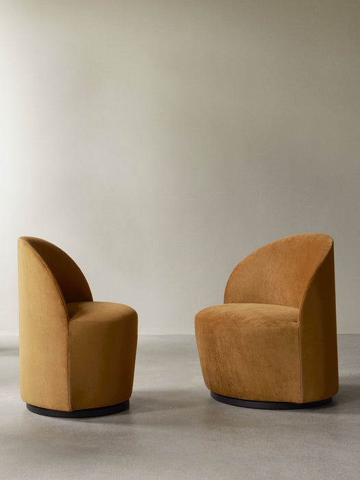 Two mustard-yellow Tearoom chairs, the Lounge Chair and the Side Chair, both with swivel bases, shown in a minimalist room.
