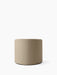 Front view of the cylindrical Tearoom Pouf, upholstered in textured, sand-coloured Logan fabric against a white background.