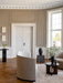A Tearoom Lounge Chair in a classic room with beige panelled walls, herringbone floors, a large window, and other furniture.