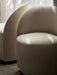 A close-up of two beige Tearoom Club Chairs, Swivel w/ Return, highlighting the curved backrest and textured upholstery.