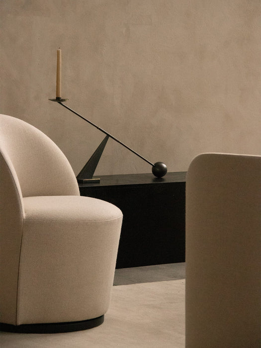 Close-up of the cream Tearoom Club Chair with swivel base, with the black Interconnect Candle Holder on a console behind it.