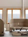 A beige Tearoom Sofa, High Back, and Lounge Chair with a marble Plinth table and a Grand Interconnect Candle Holder.