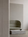 Side view of a light grey Tearoom Sofa, High Back in a minimal room. A marble coffee table holds a dark Fragilis Bowl.