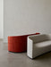 Two curved Tearoom Sofas, one in a light grey fabric and one in a burnt orange velvet, in a minimalist room.