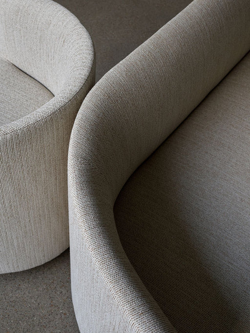 A close-up image of the Tearoom Sofa, showcasing the textured light fabric and the elegant, curved lines of its backrest.