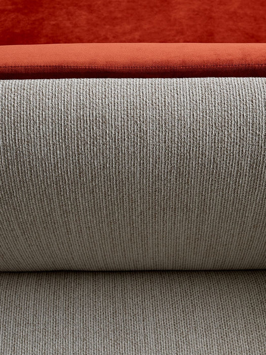 A close-up of the Tearoom Sofa, showing the textured beige Savanna fabric and a plush rust-orange velvet cushion.
