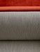 A close-up of the Tearoom Sofa, showing the textured beige Savanna fabric and a plush rust-orange velvet cushion.