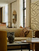 A light-coloured bouclé Tearoom Sofa in a styled living room with a coffee table, abstract art, and an oval mirror.
