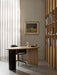 The Eclipse Desk in natural oak shown in a home office with a Harbour Dining Chair, a Column Table Lamp, and a bookcase.