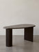 The Eclipse Desk in black lacquered oak, with a curved asymmetrical top, a cylindrical leg and a flat panel leg.