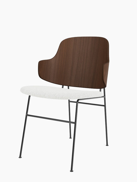 Angled view of The Penguin Dining Chair with a walnut veneer back, light grey Hallingdal fabric seat, and black steel frame.