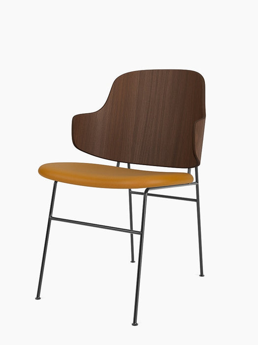 The Penguin Dining Chair with a walnut backrest, mustard yellow Dakar 0250 upholstered seat, and black steel frame.