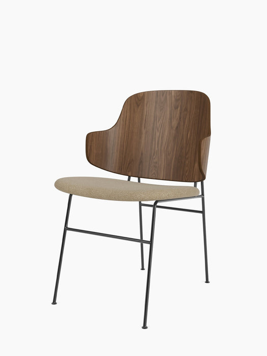 Three-quarter back view of The Penguin Dining Chair with a walnut veneer back, beige upholstered seat, and black metal legs.
